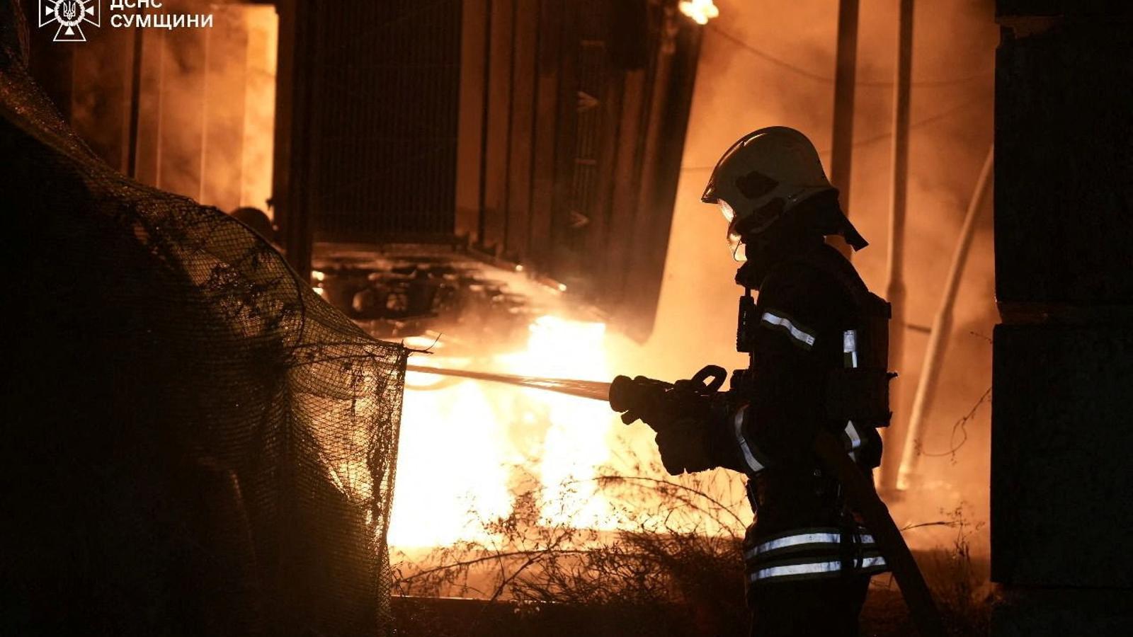 Members of the Ukrainian emergency services are trying to put out a fire caused by a drone attack in the city of