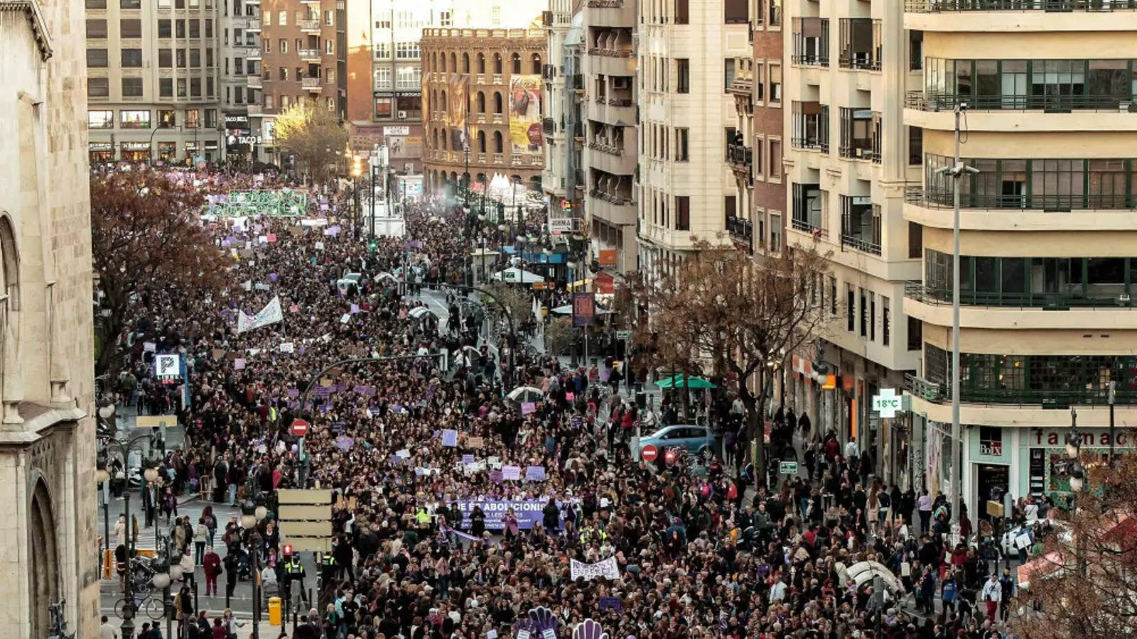 (1) Imatge de la manifestació feminista de València al seu pas pel carrer Colom. (2) Vista general de la marxa pels drets de les dones a Madrid.