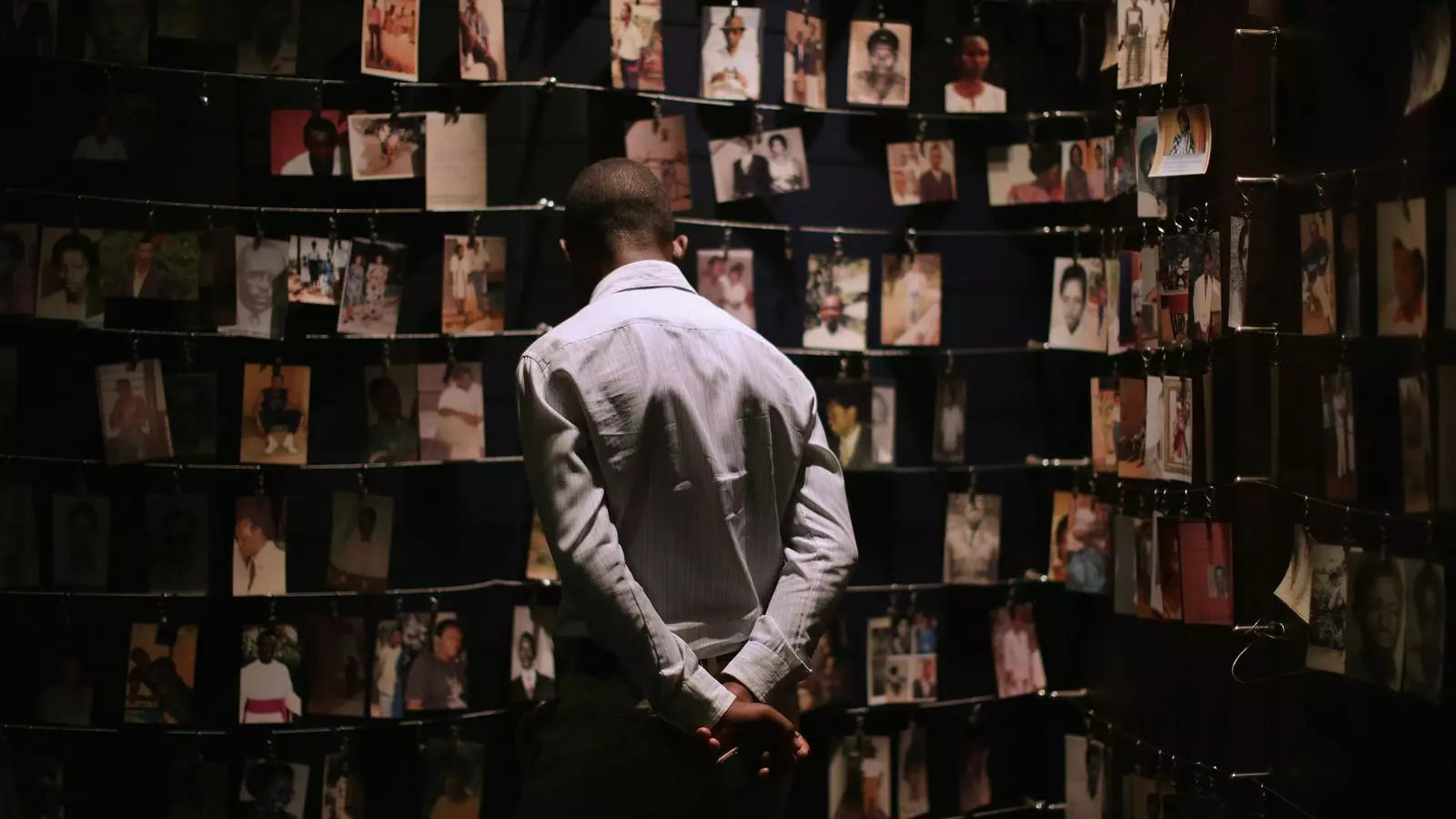 Un home mira retrats de les víctimes del genocidi de Ruanda en una sala del Centre Memorial del Genocidi ruandès a Kigali.