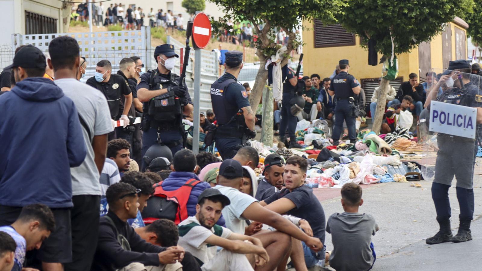 Migrants sitting outside one of the facilities where reception places have been opened, in Ceuta.