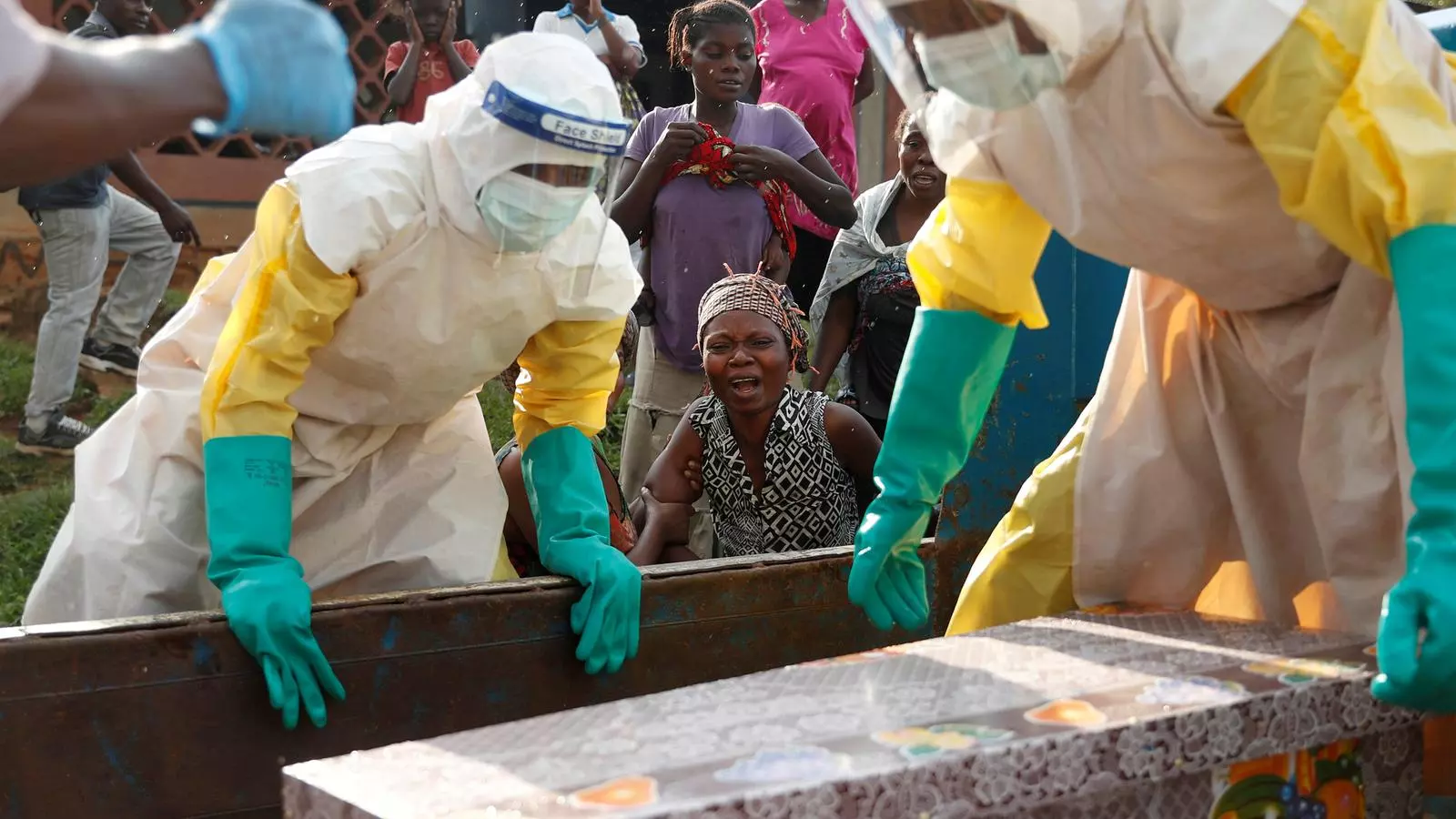 La mare d'un infant mort per, suposadament, el brot d'Ebola plora mentre els equips d'emergència s'enduen el cadàver del fill.