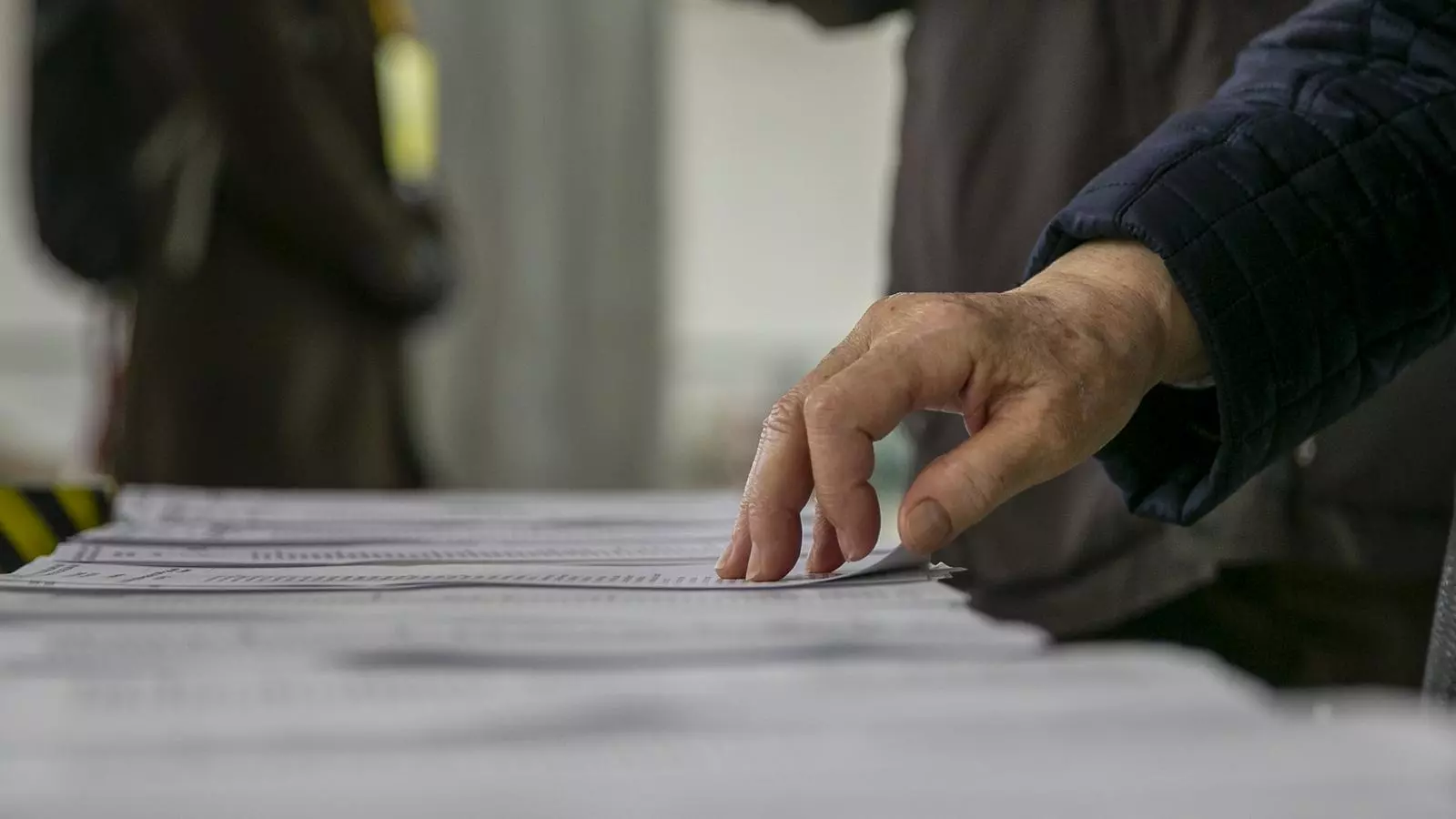 Una persona escull la papereta durant les eleccions del 14 de febrer.