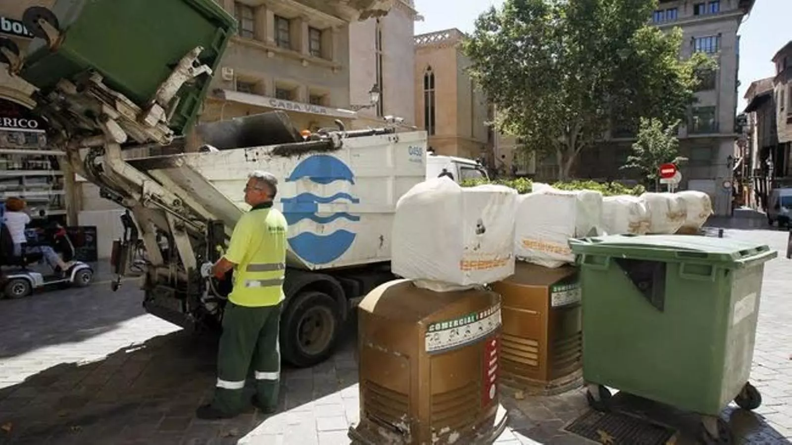 Camions recollint els residus del contenidors, durant el dia.