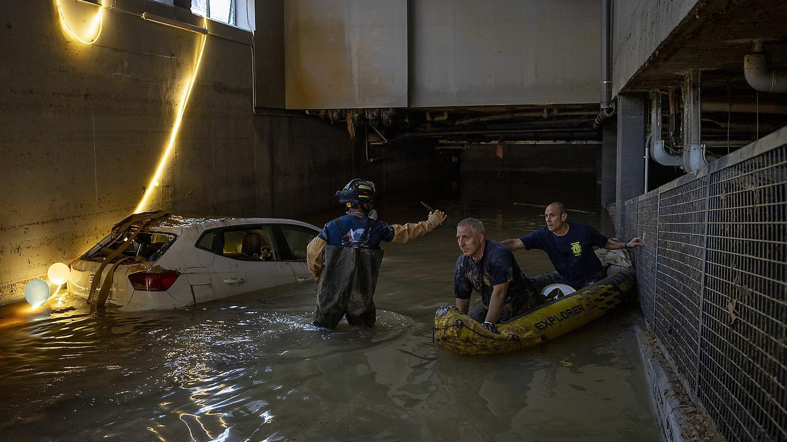 Firefighters rescue a vehicle from the underground parking lot of the Mercadona in Paiporta. FRANCISCO MELCION