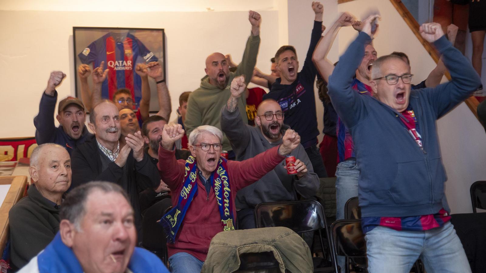 socios de la Peña Barcelonista de Arnes mirando el Barça-Madrid