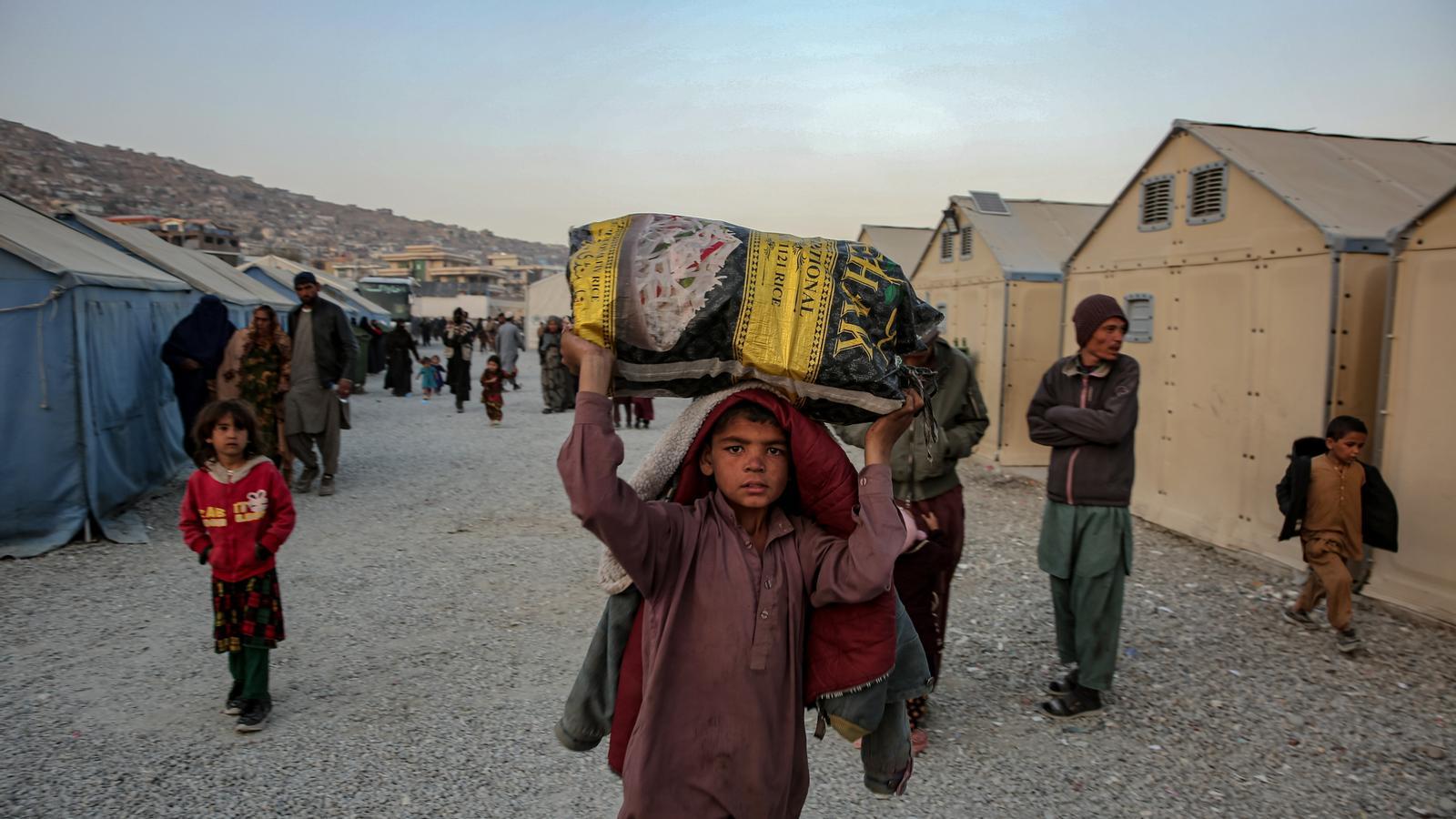 Afghan refugees wait in a camp, after being returned from neighboring countries, Pakistan and Iran.