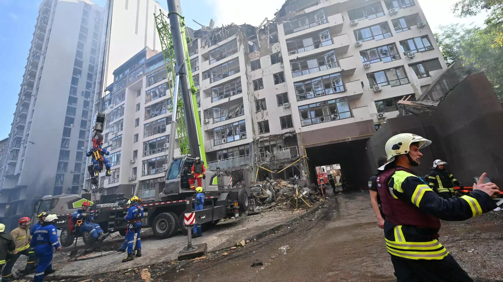 Els equips de rescat treballen a l'edifici residencial de Kíiv on aquest diumenge ha caigut un projectil rus.