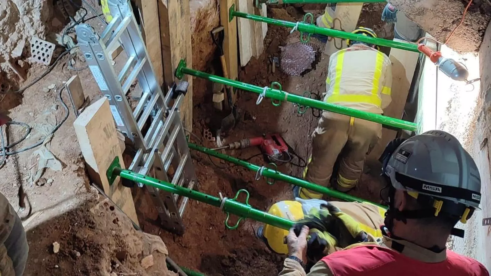 Els Bombers treballant en el rescat de l'home sepultat.