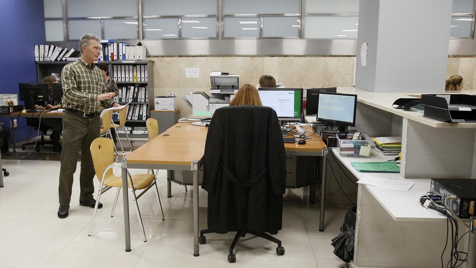 Funcionaris treballant en una oficina de l'administració de Justícia