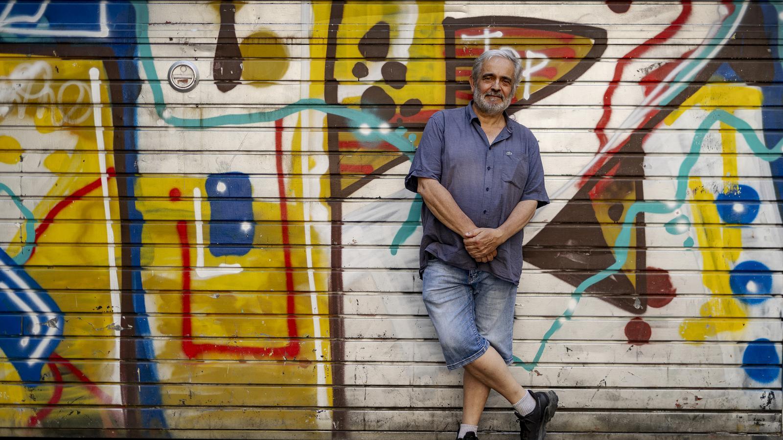 Joan Maria Minguet pidió que lo retrataran delante de unos grafitis. Los reivindica como una de las formas de arte que consigue escabullirse del sistema, son "la voz de los invisibles".